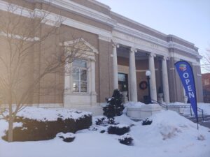 Patterson Library in the snow with an open sign out front